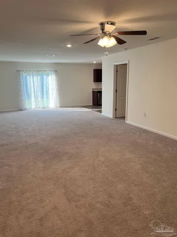 a view of empty room with a ceiling fan and window