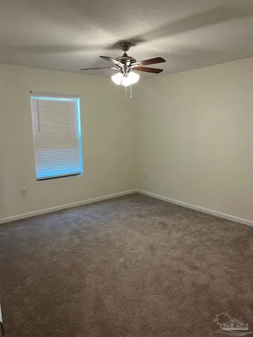 an empty room with a window and a fan