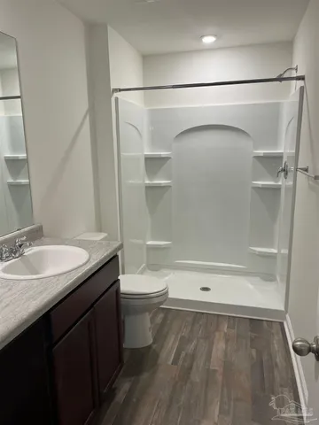 a bathroom with a granite countertop sink toilet and shower
