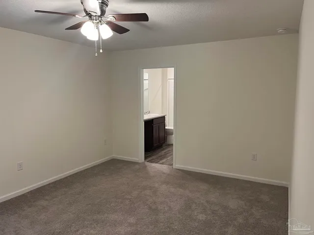 an empty room with a chandelier fan and a ceiling fan