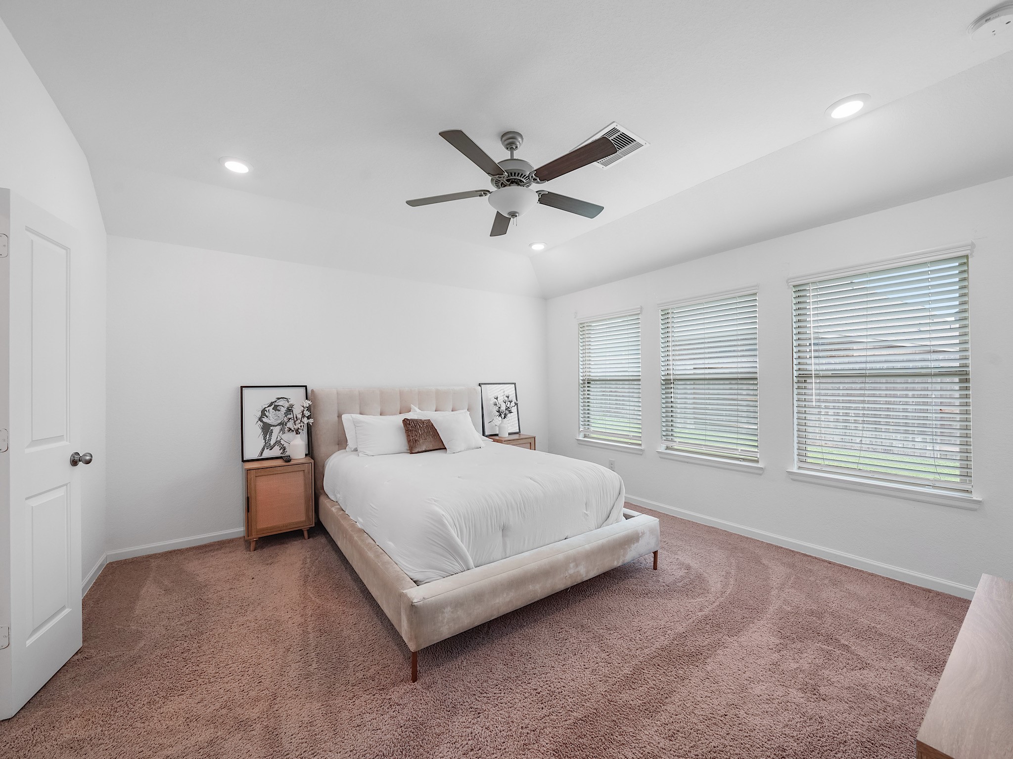 6210 Glenwick Park Road Katy, TX 77493 - Photo 14 of 25 Unwind in this expansive primary suite featuring soft carpet, a tray ceiling with recessed lighting, and three large windows that flood the room with natural light—perfectly sized for a king bedroom set.