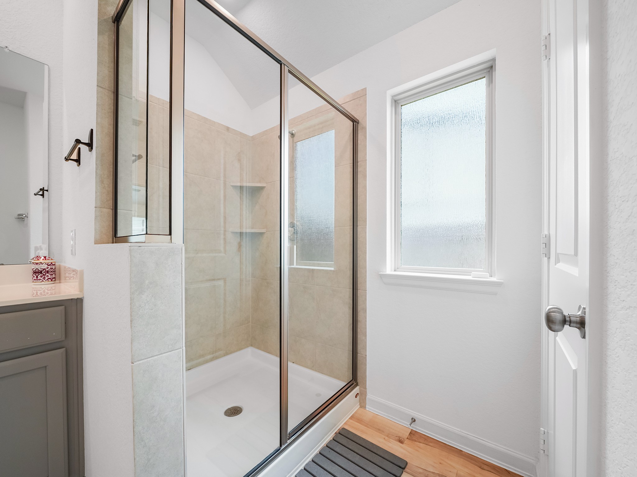 6210 Glenwick Park Road Katy, TX 77493 - Photo 18 of 25 Enjoy the luxury of a spacious, frameless glass walk-in shower—designed for relaxation with built-in shelving and neutral tile for a timeless look.