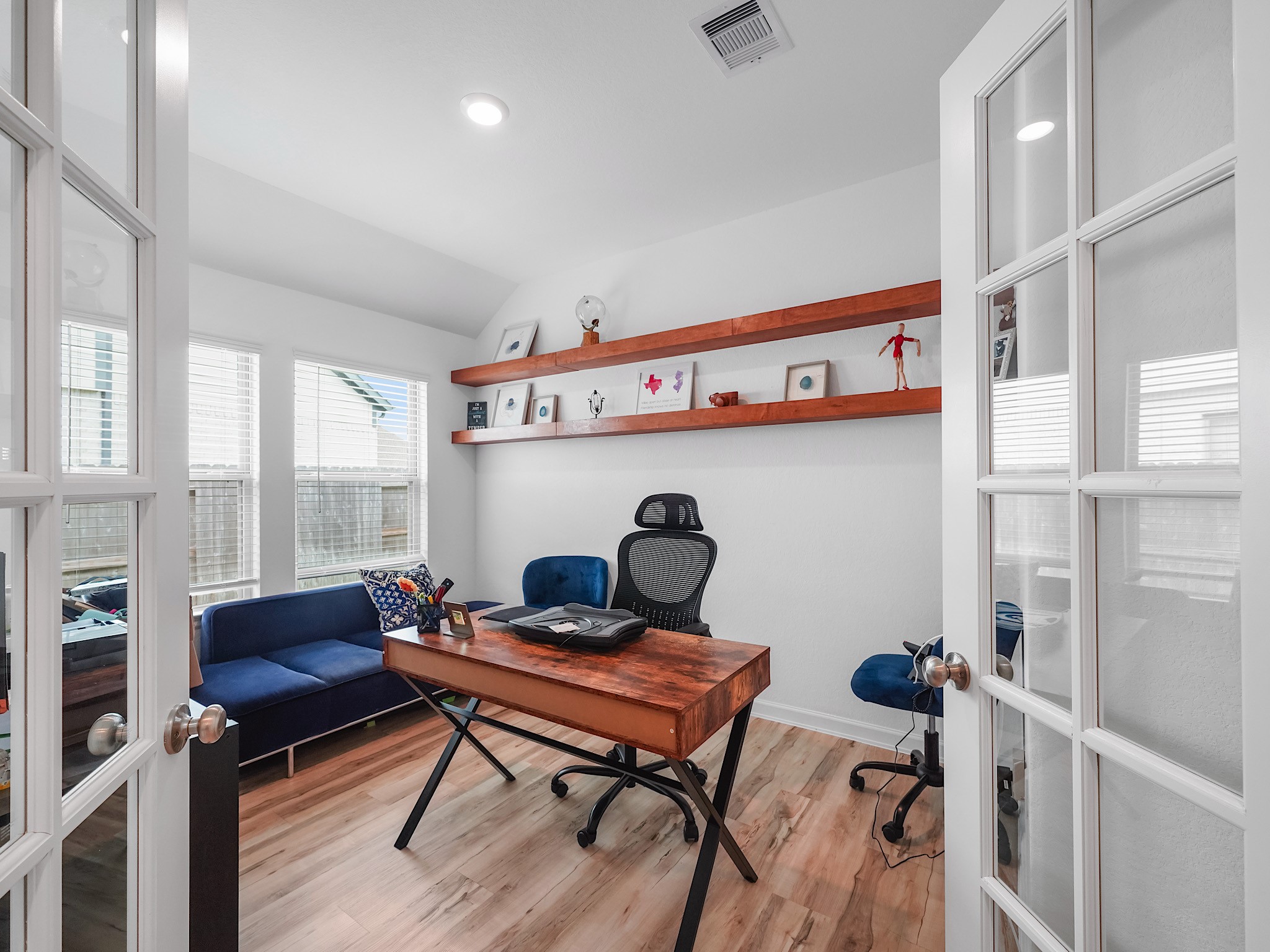 6210 Glenwick Park Road Katy, TX 77493 - Photo 2 of 25 Work from home in style! This dedicated office space features French doors, abundant natural light, and custom wall shelving—perfect for creating a productive, stylish workspace or even a cozy reading nook.
