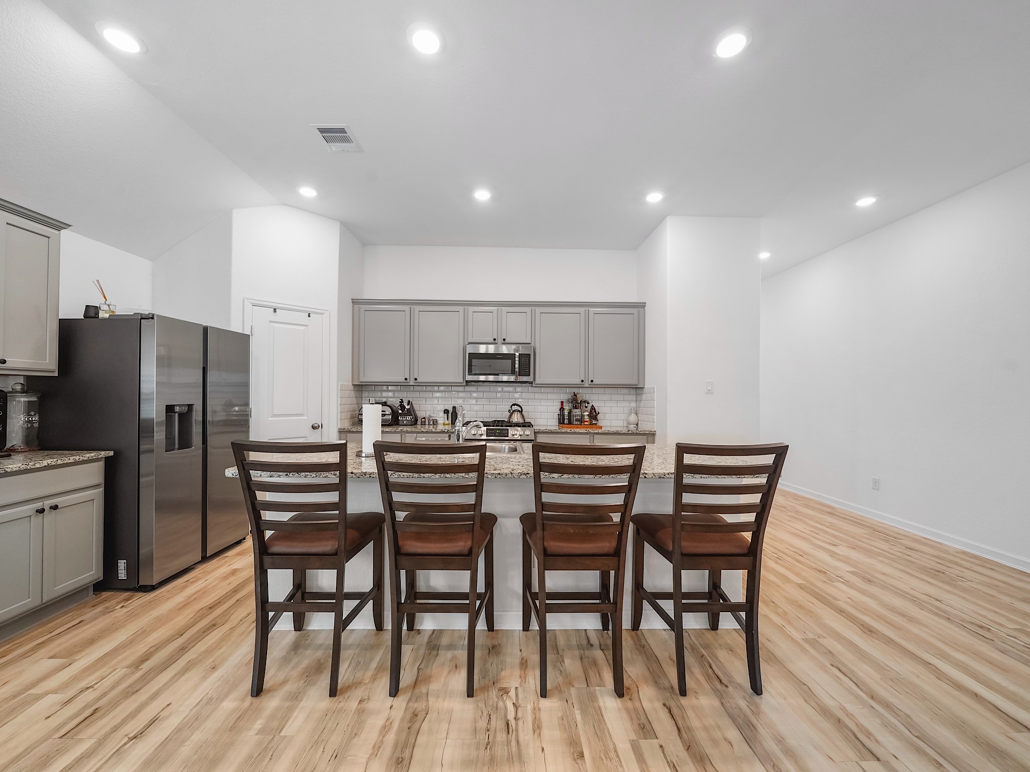 6210 Glenwick Park Road Katy, TX 77493 - Photo 5 of 25 This kitchen is built for everyday living and entertaining! A generous granite island offers bar seating for four, complemented by modern cabinetry, subway tile backsplash, and stainless steel appliances.