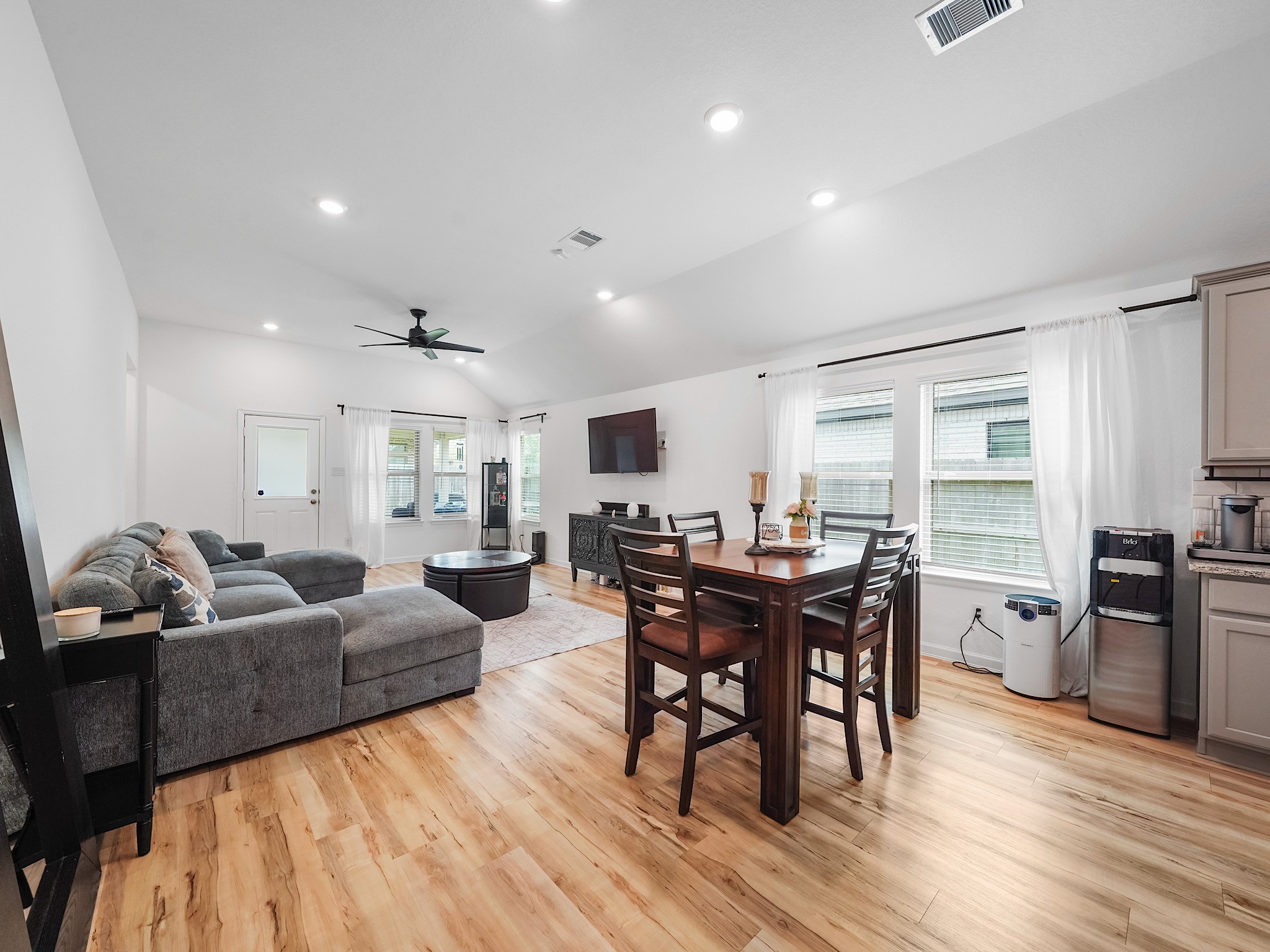 6210 Glenwick Park Road Katy, TX 77493 - Photo 9 of 25 The seamless transition from dining to living space creates an inviting atmosphere for entertaining or everyday comfort, all under soaring ceilings and enhanced by recessed lighting.