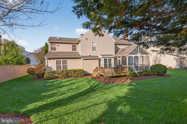 a view of a house with a big yard and large trees