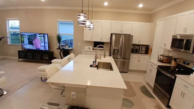 a kitchen with stainless steel appliances wooden floor dining table and chairs