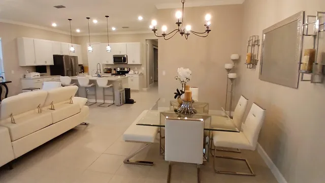 a living room with furniture kitchen view and a chandelier