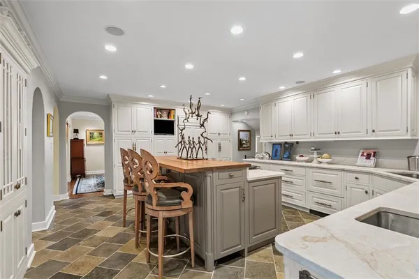 a kitchen with stainless steel appliances kitchen island granite countertop a table chairs sink and cabinets