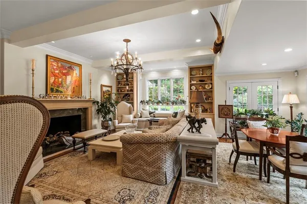 a living room with furniture a fireplace and a chandelier
