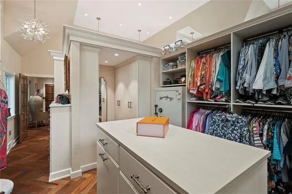 a view of walk in closet with clothes and shoes