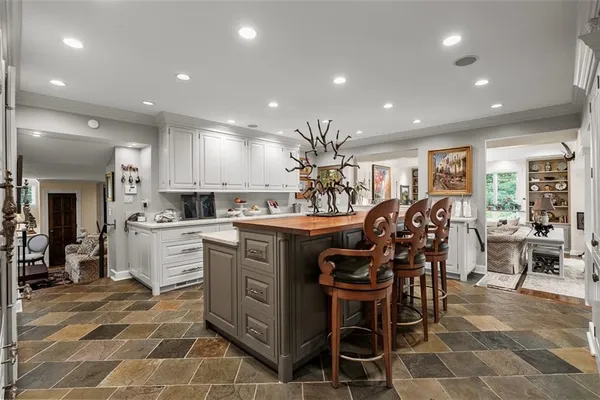 a kitchen with stainless steel appliances kitchen island granite countertop a table and chairs in it