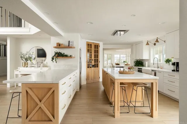 a large white kitchen with a sink and cabinets