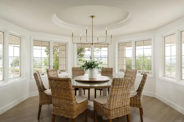 a dining room with furniture a chandelier and wooden floor