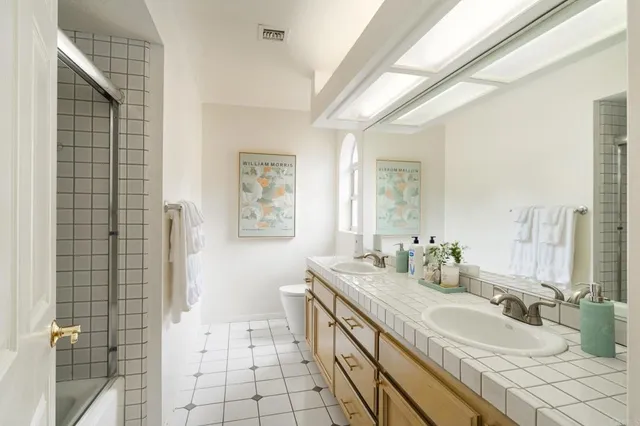 a bathroom with a double vanity sink a mirror and a shower