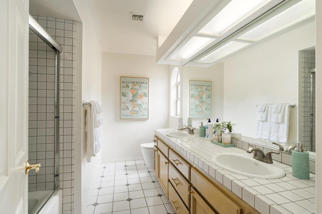 12212 Rockstream Road Lakeside, CA 92040 - Photo 23 of 36 a bathroom with a double vanity sink a mirror and a shower
