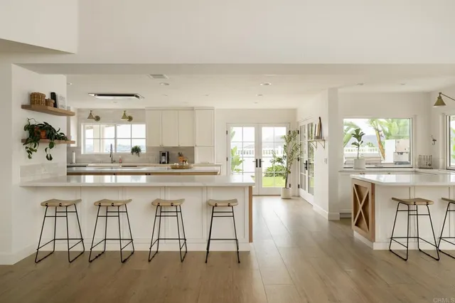 a kitchen with white cabinets and chairs