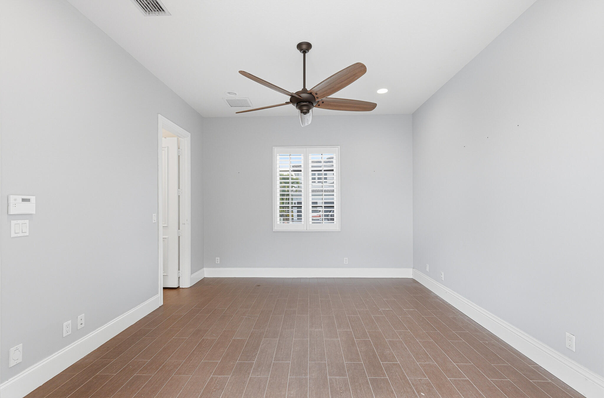 17550 Circle Pond Court Boca Raton, FL 33496 - Photo 71 of 99 an empty room with wooden floor ceiling fan and windows