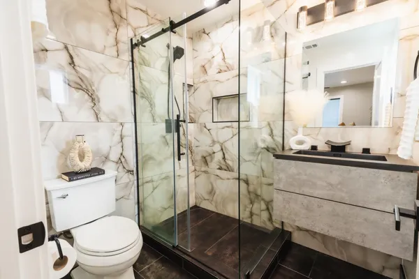 a bathroom with a shower a toilet and sink