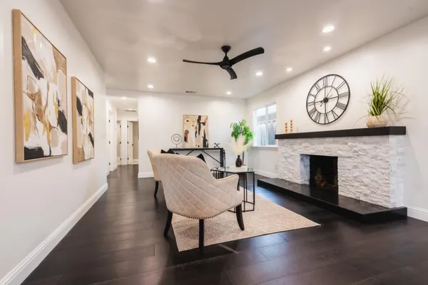 a living room with furniture a fireplace and a wall painting