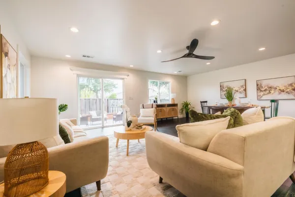 a living room with furniture ceiling fan and a wooden floor