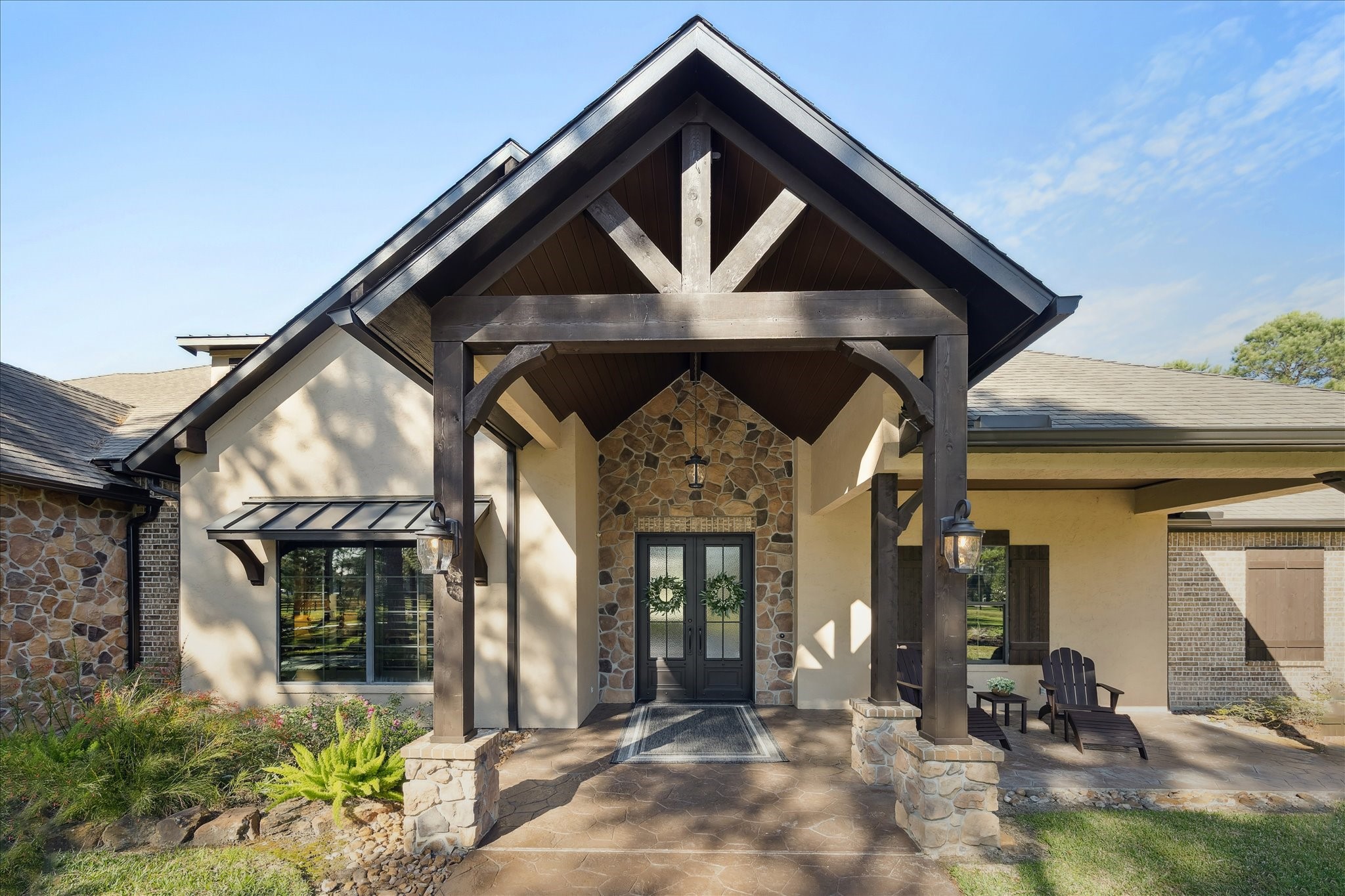 11 Willowcreek Ranch Road Tomball, TX 77377 - Photo 6 of 49 Guests are welcome by a set of custom steel and glass doors, the focal point of the vaulted covered veranda boasting cedar posts, beams, and are finished with tongue and groove on the ceiling.