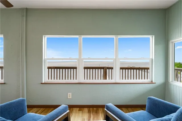 a blue room with wooden floor and windows
