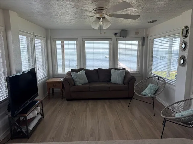 a living room with furniture a flat screen tv and windows