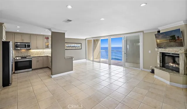 a view of kitchen with granite countertop cabinets and refrigerator