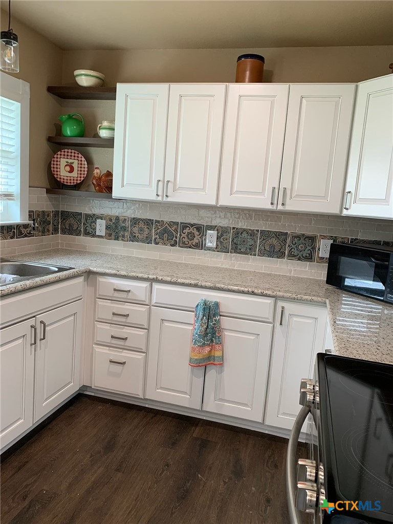 952 Fannin Loop Temple, TX 76501 - Photo 7 of 17 a kitchen with white cabinets and sink