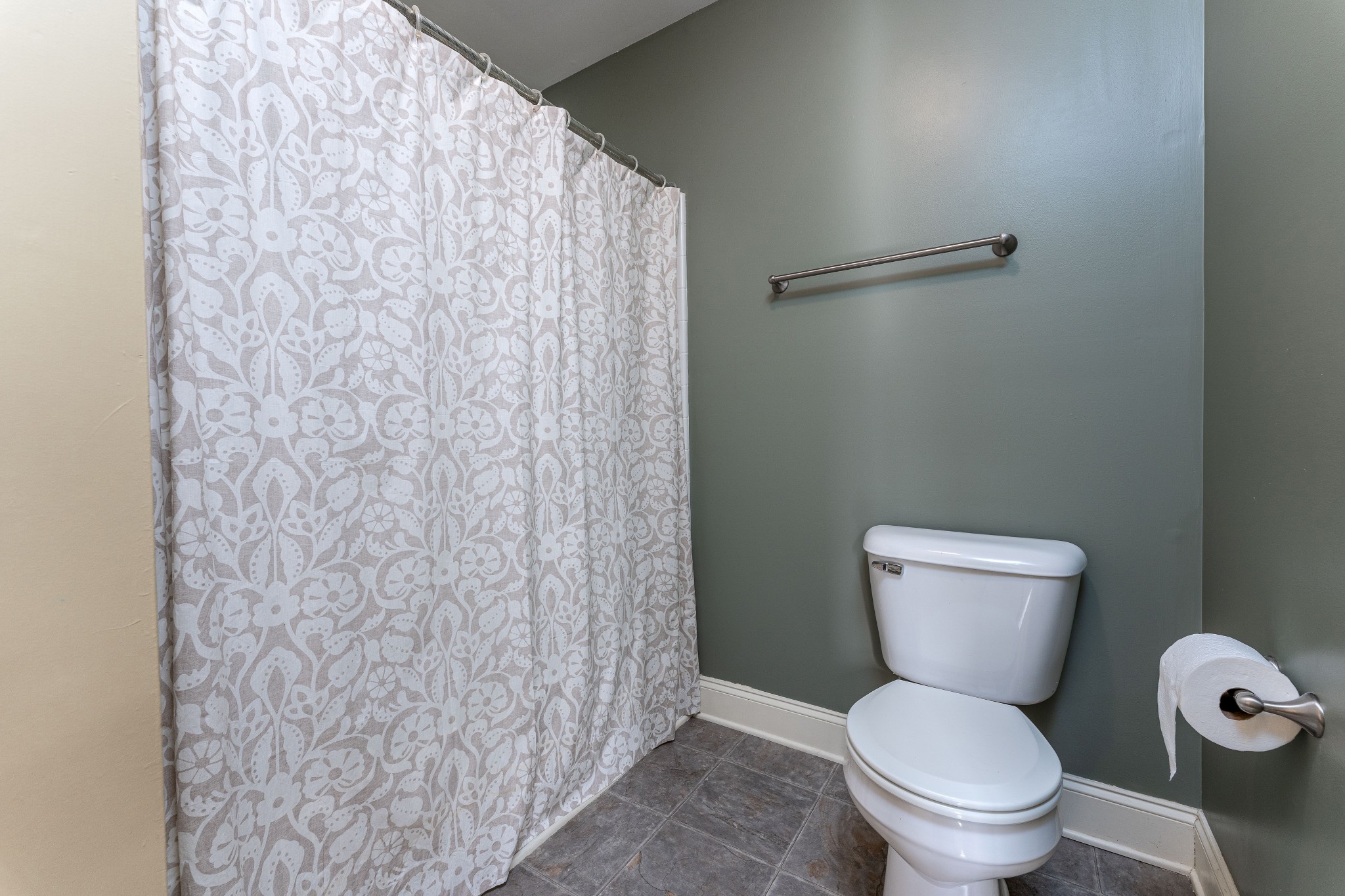 735 Tulip Grove Road, Unit 210 Hermitage, TN 37076 - Photo 21 of 32 a white toilet sitting next to a shower curtain