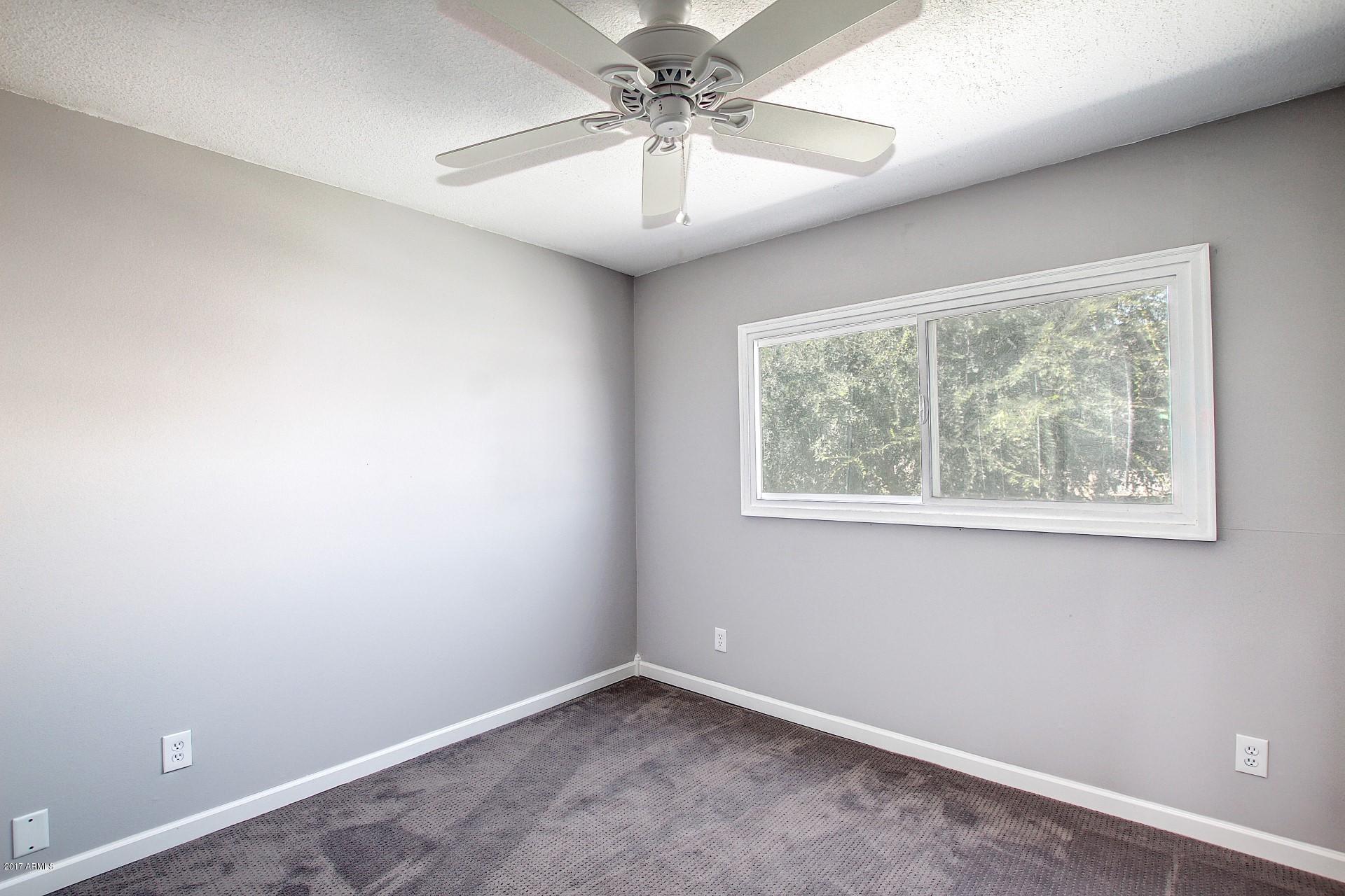6909 East Osborn Road, Unit F Scottsdale, AZ 85251 - Photo 14 of 55 an empty room with a window and a chandelier fan