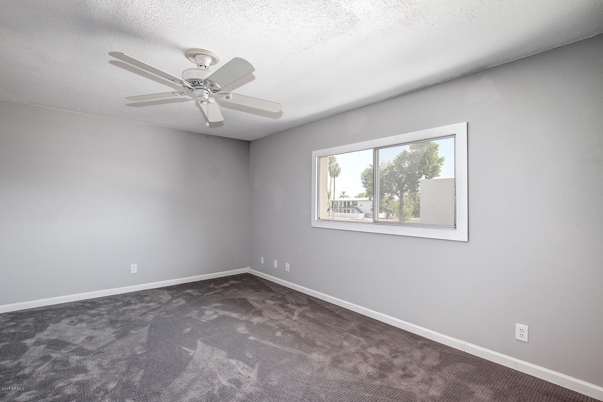 6909 East Osborn Road, Unit F Scottsdale, AZ 85251 - Photo 20 of 55 an empty room with a window and ceiling fan