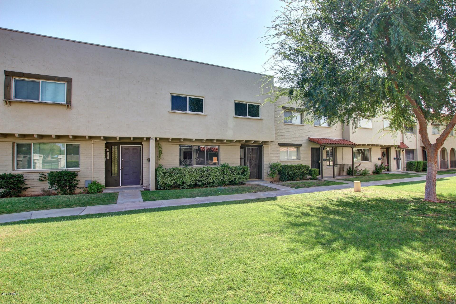 6909 East Osborn Road, Unit F Scottsdale, AZ 85251 - Photo 25 of 55 a front view of a house with a yard and garage