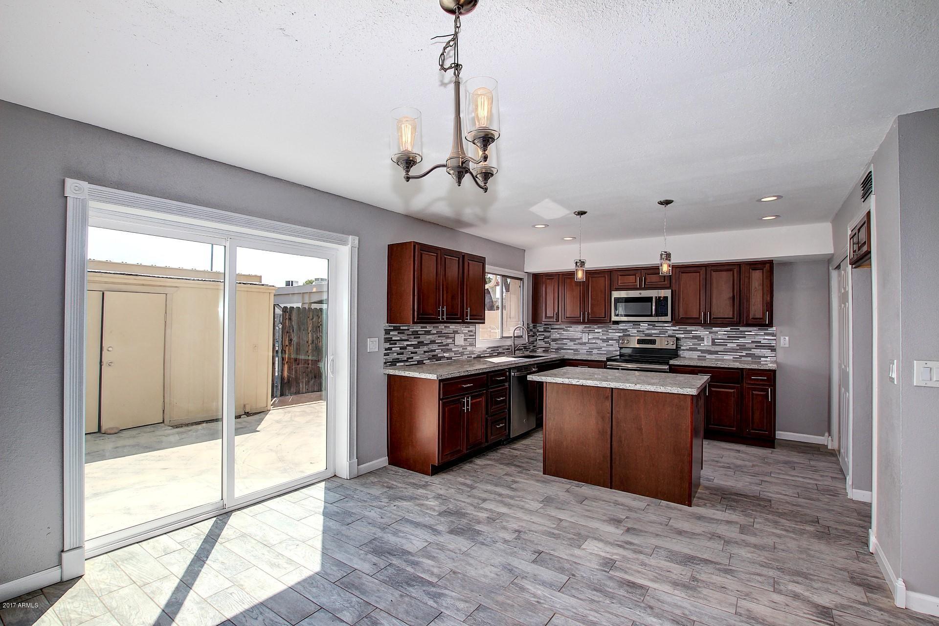 6909 East Osborn Road, Unit F Scottsdale, AZ 85251 - Photo 3 of 55 a large kitchen with stainless steel appliances granite countertop a stove and a refrigerator