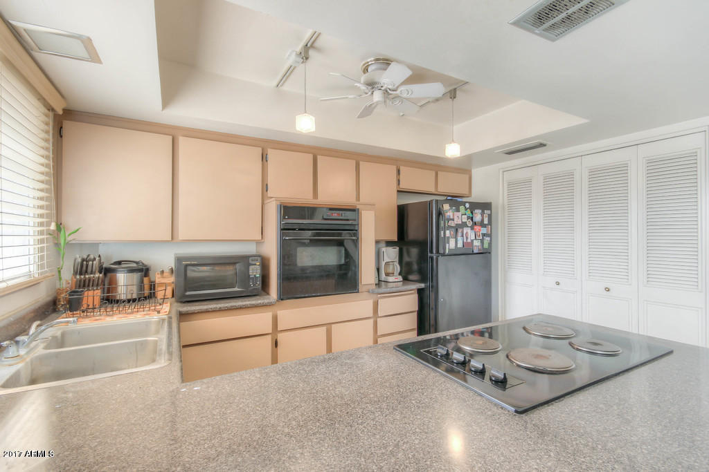 6909 East Osborn Road, Unit F Scottsdale, AZ 85251 - Photo 50 of 55 a kitchen with stainless steel appliances granite countertop a sink and cabinets