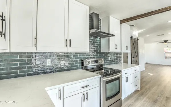 a kitchen with granite countertop a sink a stove and cabinets
