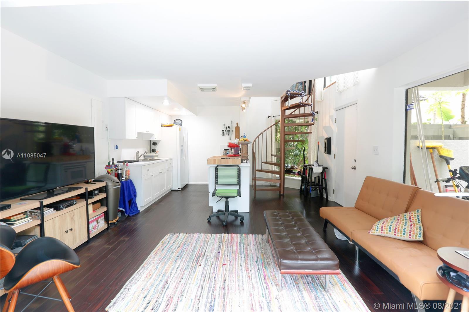3034 Southwest 27th Avenue, Unit 4 Miami, FL 33133 - Photo 5 of 15 a living room with furniture and a flat screen tv