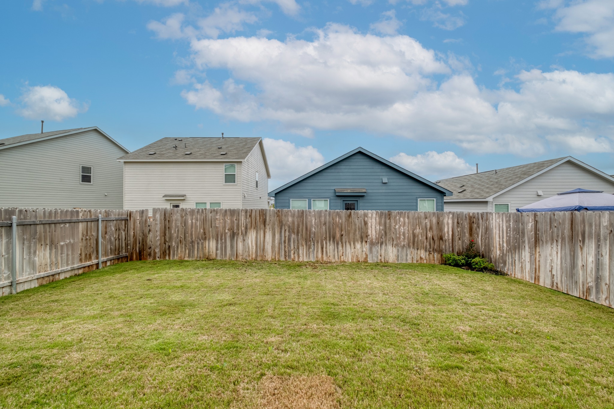 23412 Tiny Moons Way Elgin, TX 78621 - Photo 33 of 38 Expansive grassy yard with a wooden privacy fence
