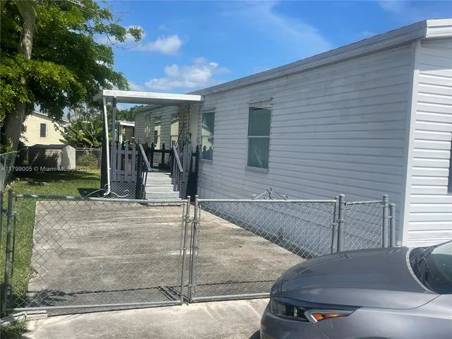 a view of a patio with table and chairs with wooden floor and fence