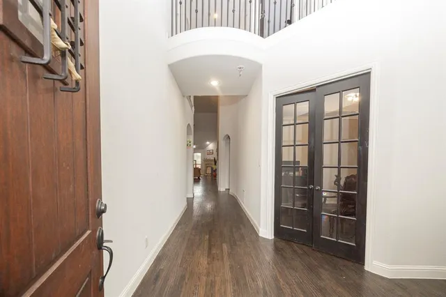 a view of a hallway with wooden floor and stairs