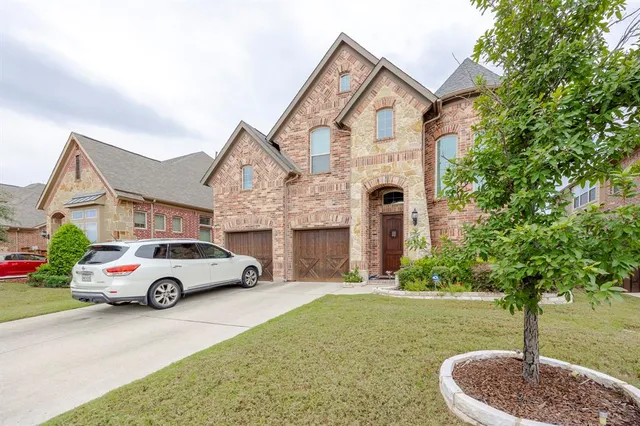a front view of a house with a garden and parking
