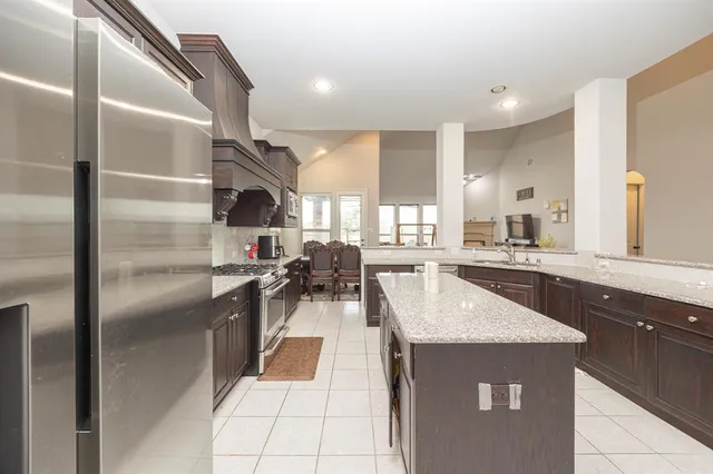 a kitchen with stainless steel appliances granite countertop a sink a stove and a refrigerator