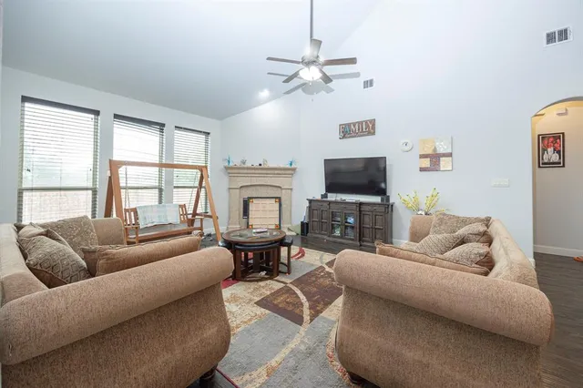 a living room with furniture a fireplace and a flat screen tv