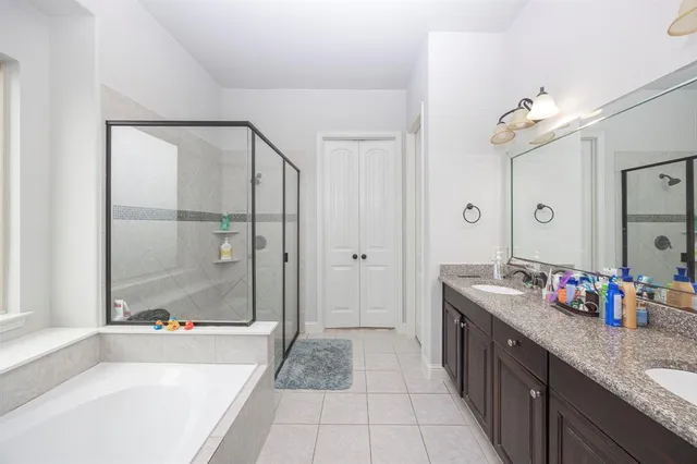 a spacious bathroom with a granite countertop sink a mirror and shower