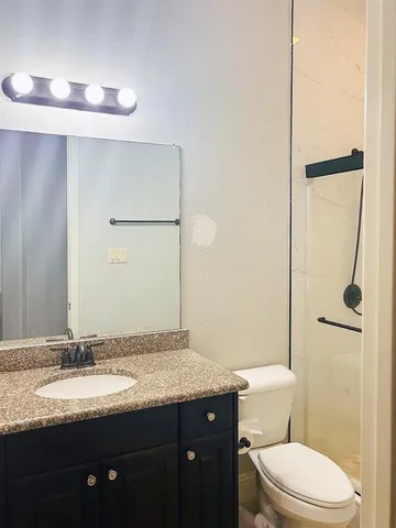 a bathroom with a granite countertop sink toilet and shower