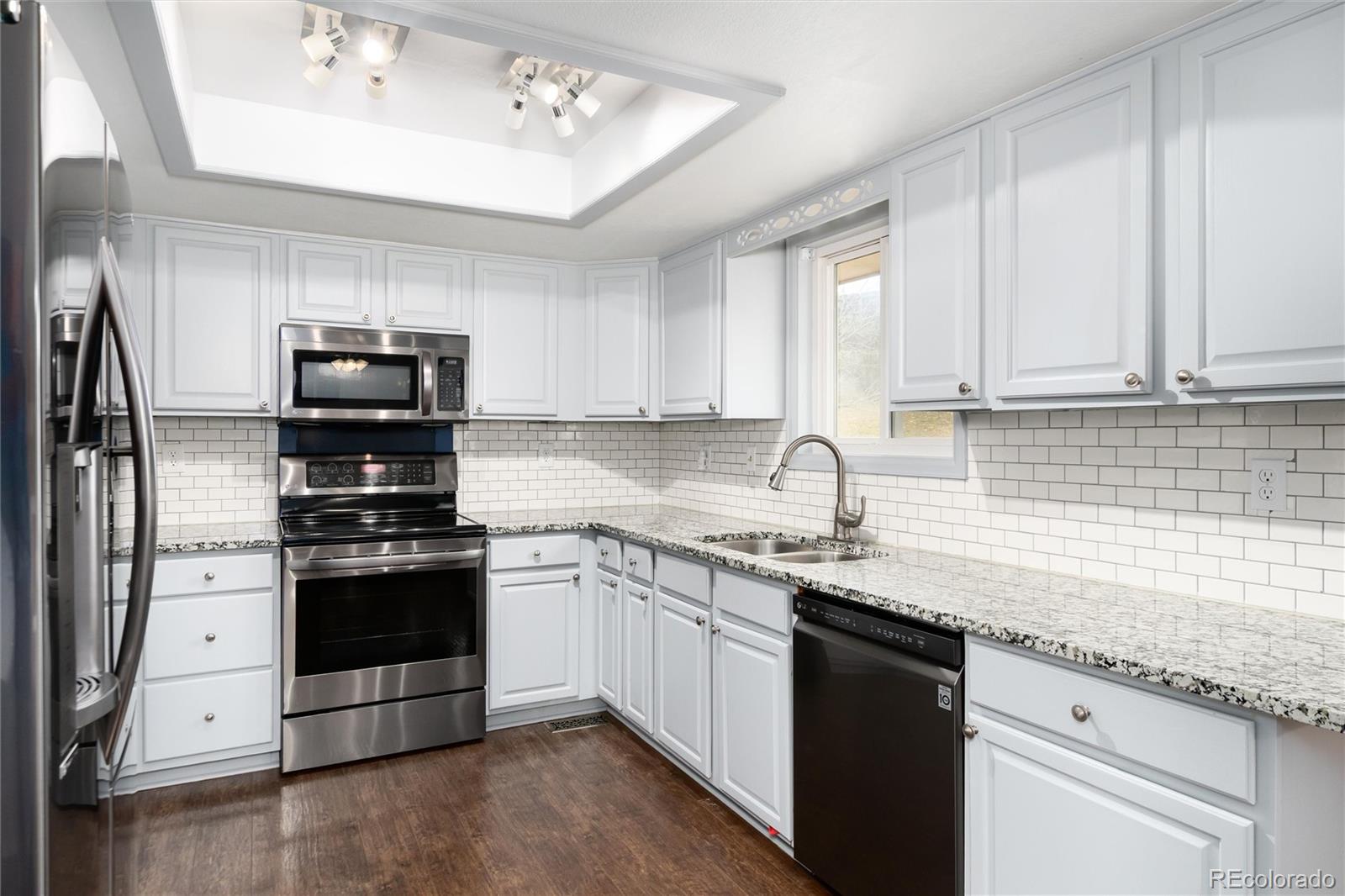 4935 South Routt Street Littleton, CO 80127 - Photo 11 of 45 a kitchen with stainless steel appliances granite countertop a sink stove and refrigerator