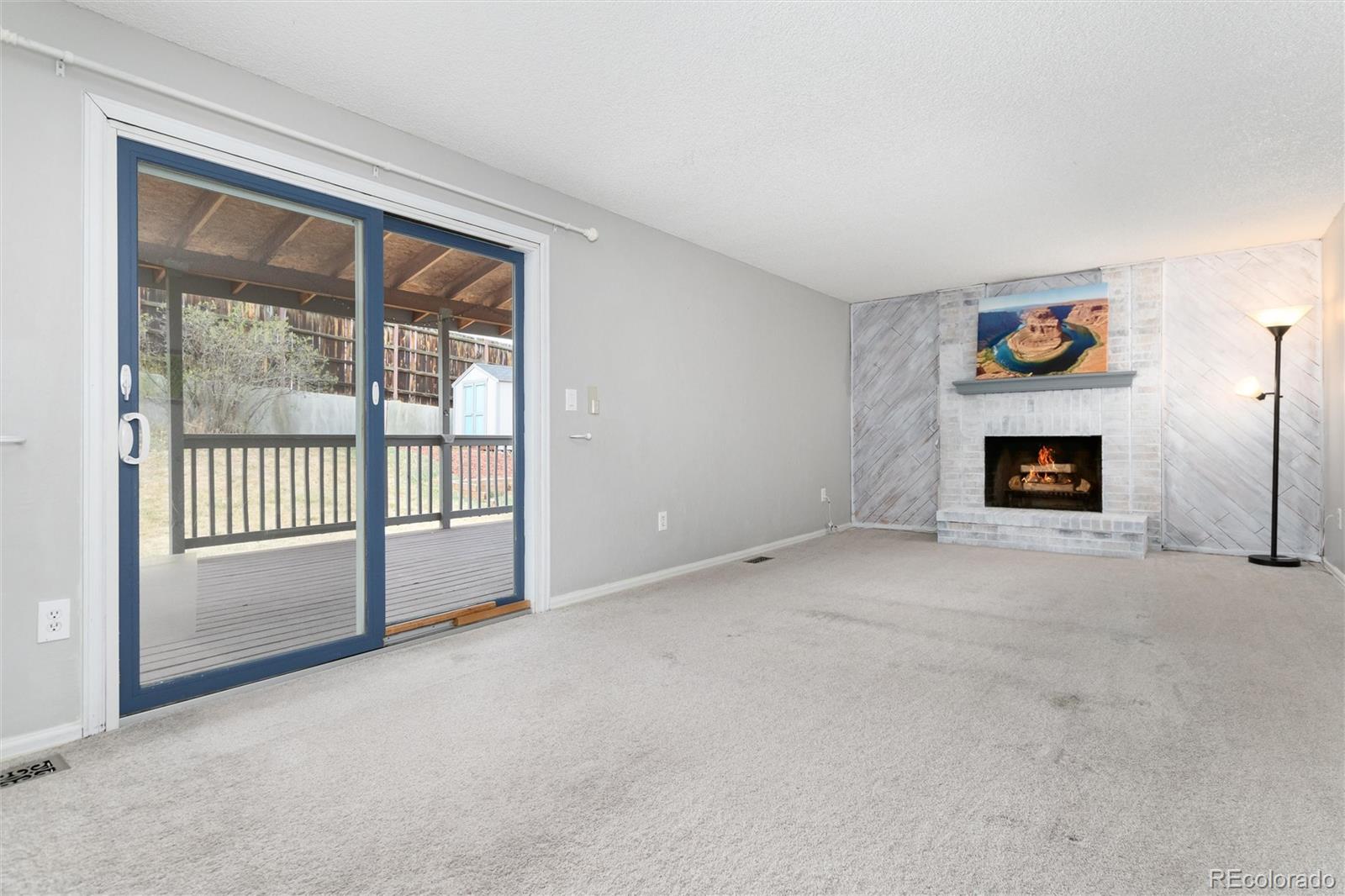 4935 South Routt Street Littleton, CO 80127 - Photo 16 of 45 a view of an empty room with a window and a fireplace