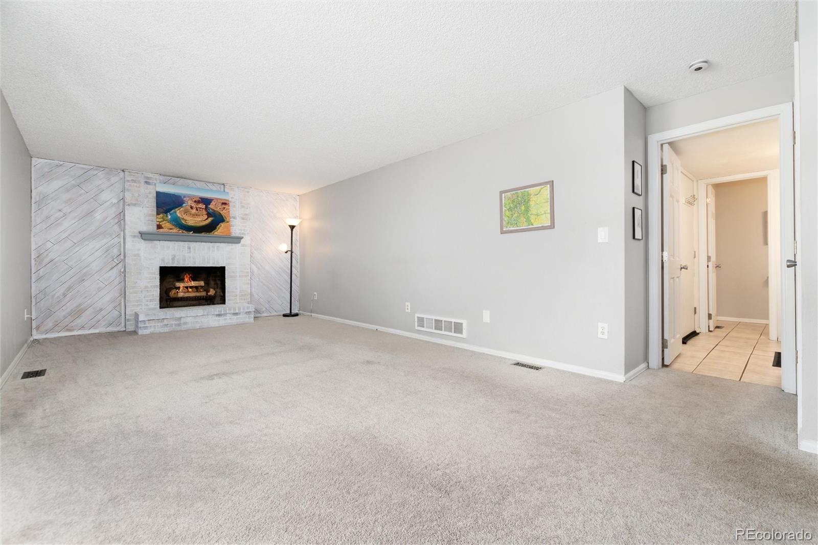 4935 South Routt Street Littleton, CO 80127 - Photo 18 of 45 a view of a livingroom with an empty space and a fireplace