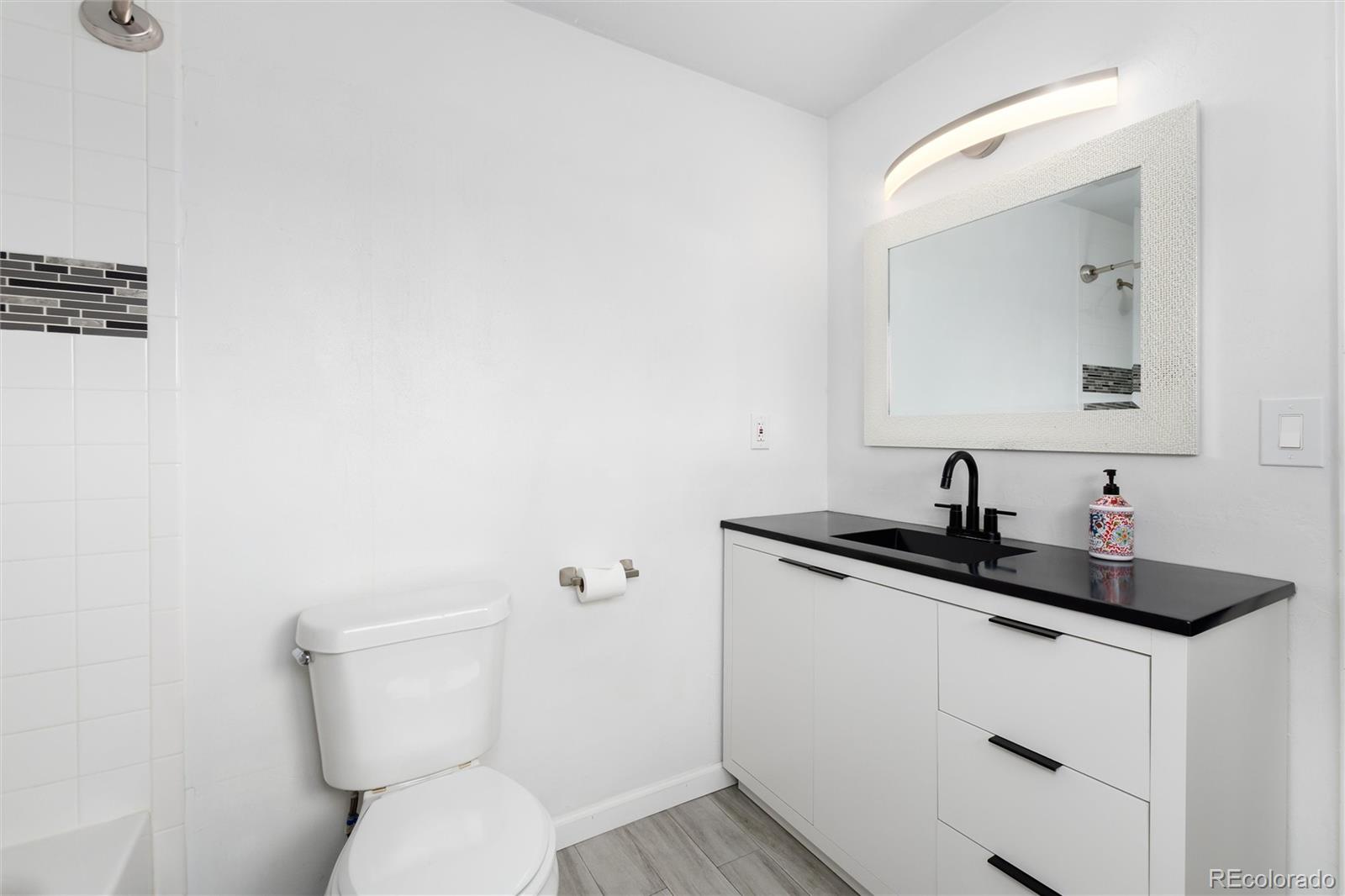 4935 South Routt Street Littleton, CO 80127 - Photo 23 of 45 a bathroom with a granite countertop toilet sink and mirror